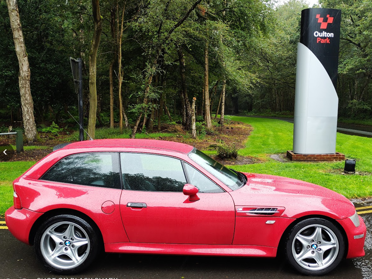 A red car parked in front of a sign

AI-generated content may be incorrect.