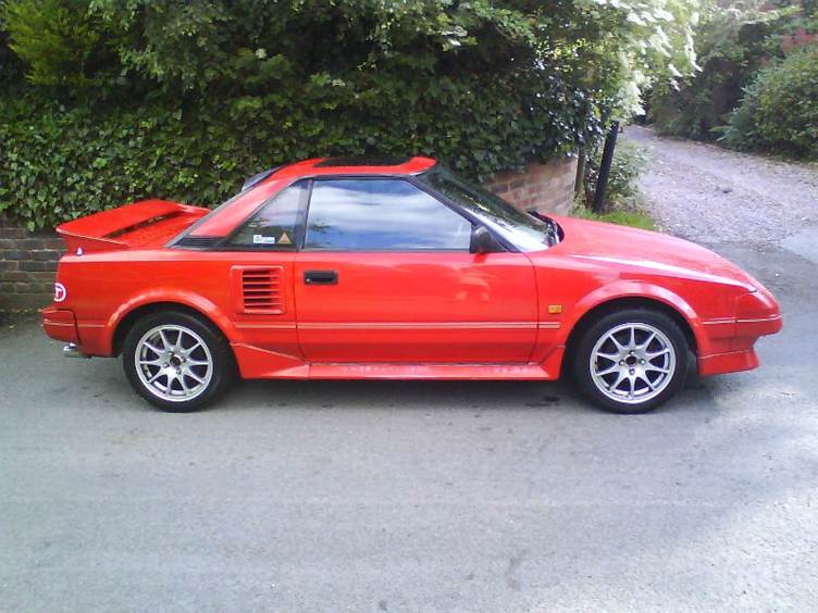 A red car parked on a road

AI-generated content may be incorrect.